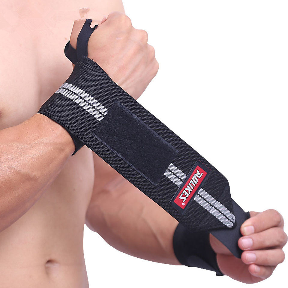 Person wearing a black wrist support strap with a visible brand logo on a plain background